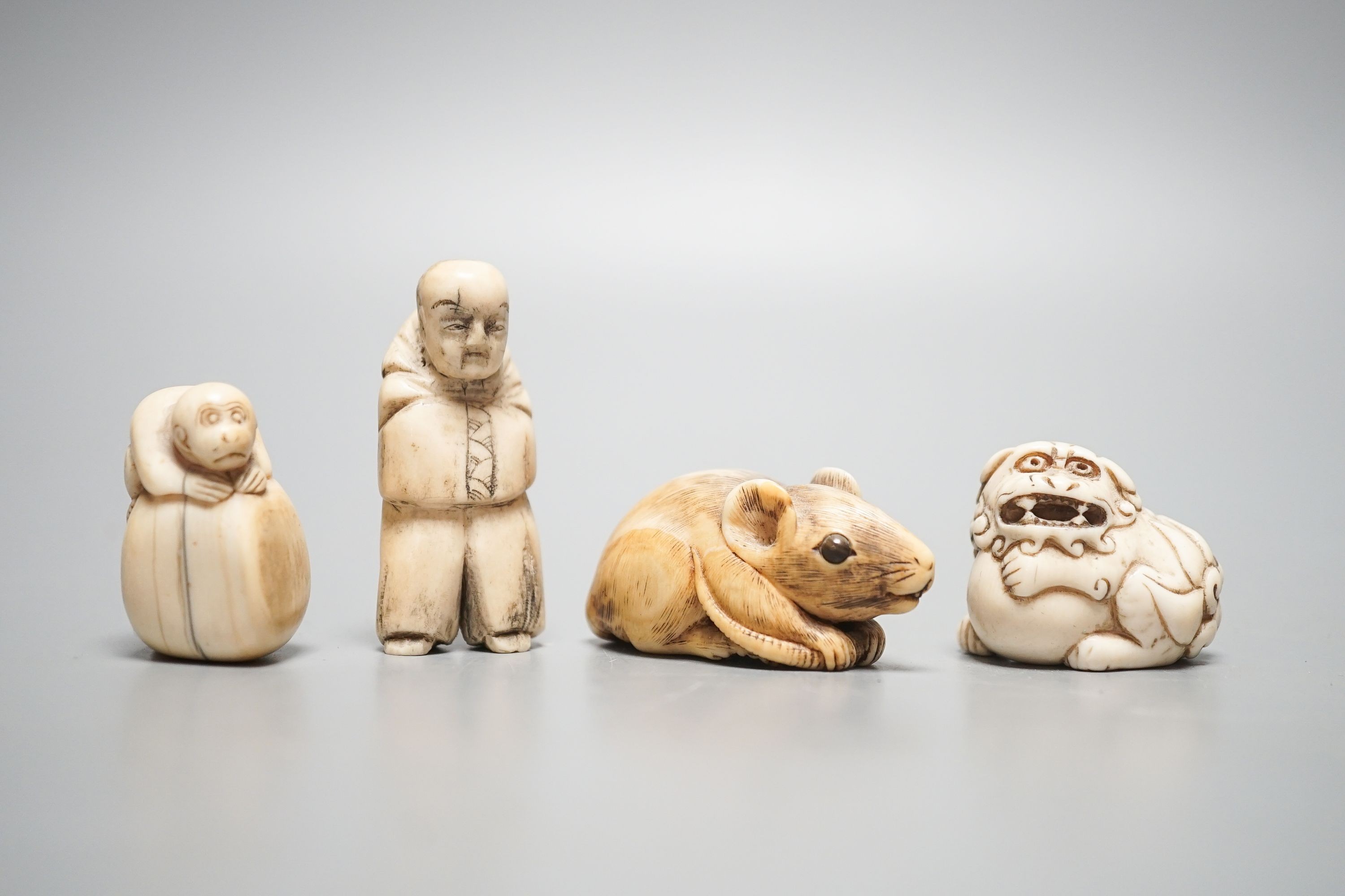 A 19th century ivory netsuke of a rat, horn inset eyes, 5.2cm, two other ivory netsuke and a stag horn netsuke (4)